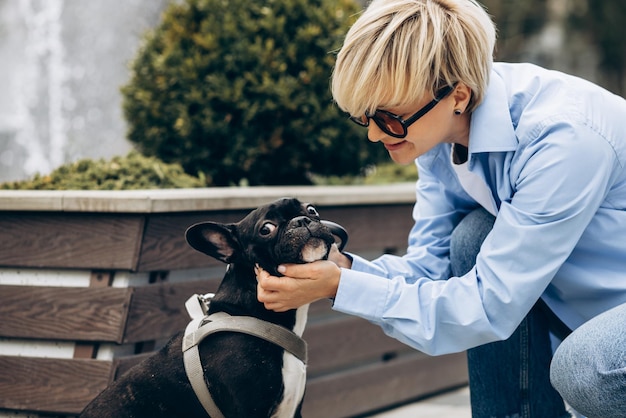 Jeune femme se promener avec son animal de compagnie bouledogue français