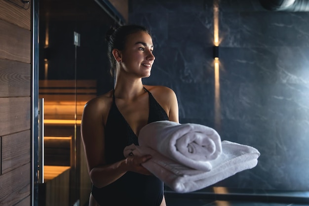 Une jeune femme se repose seule dans un sauna