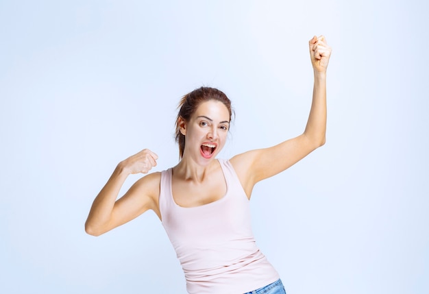 La jeune femme se sent heureuse et montre des signes positifs de la main