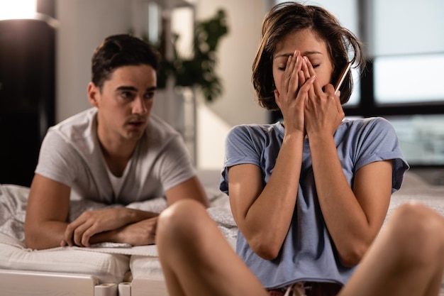 Jeune femme se sentant frustrée tout en ayant des problèmes relationnels et en se disputant avec son petit ami dans la chambre