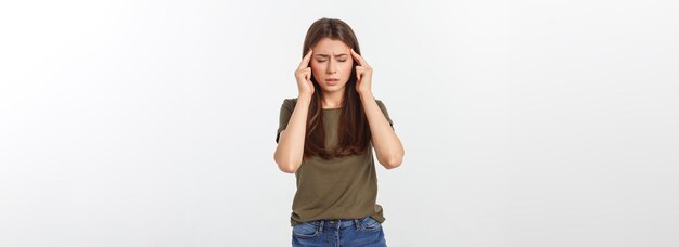 Une jeune femme séduisante souffrant de maladie ou de maux de tête tenant sa tête isolée sur blanc