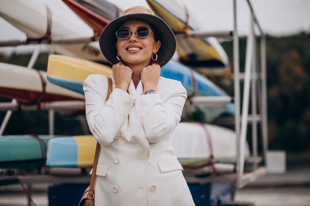 Photo gratuite jeune femme séduisante en veste blanche marchant à l'extérieur