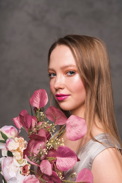 Jeune femme sensuelle au bouquet de belle fleur