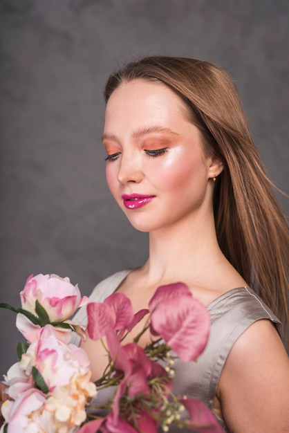 Jeune femme sensuelle avec bouquet de belle fleur
