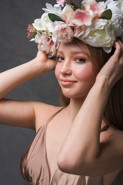 Jeune femme sensuelle en robe avec couronne de belle fleur