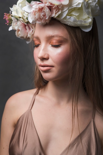 Jeune femme sensuelle en robe avec couronne de belle fleur