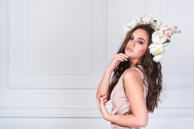 Photo gratuite jeune femme sensuelle en robe avec des fleurs fraîches sur la tête