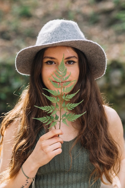 Photo gratuite jeune femme, sentir, feuille, forêt