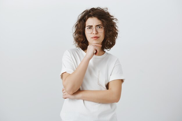 Jeune femme sérieuse à la prise de décision, à la réflexion, en choisissant