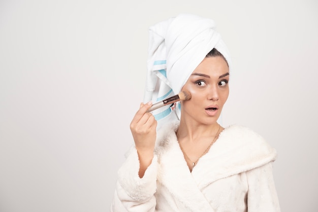 Jeune femme avec une serviette sur la tête et un pompon