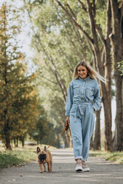 Jeune femme avec son animal de compagnie bouledogue français dans le parc