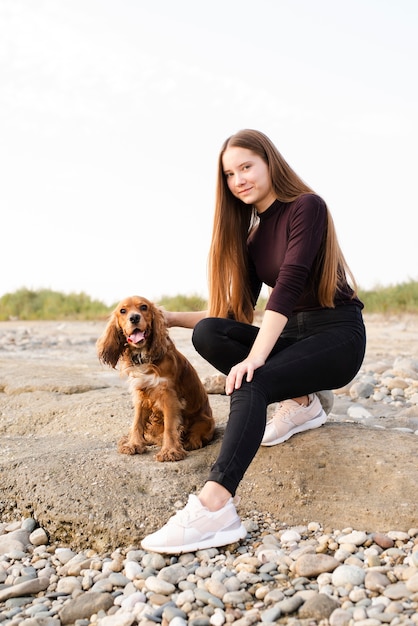 Jeune femme avec son chien mignon en plein air