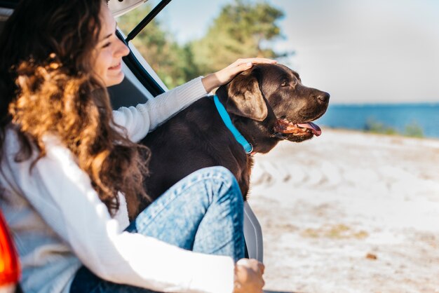 Jeune femme avec son chien à la plage