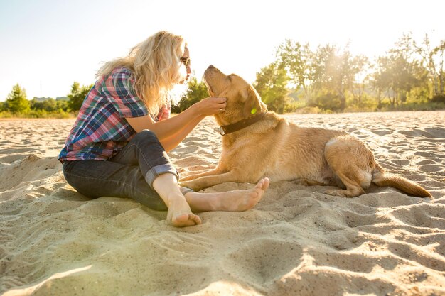 Jeune femme avec son chien à la plage