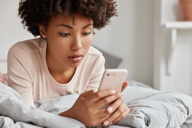 jeune femme avec son téléphone posant à la maison