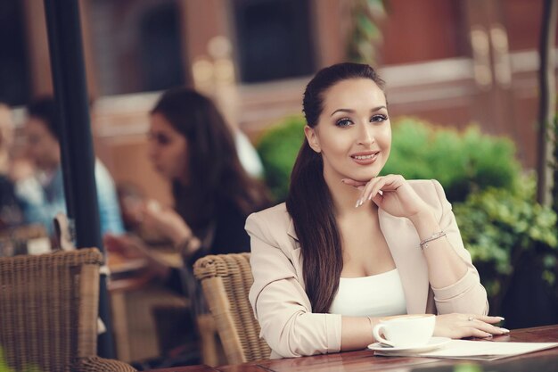 jeune femme souriante au restaurant café en plein air