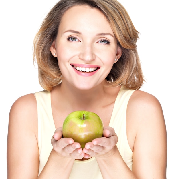 Jeune femme souriante heureuse avec pomme verte isolée sur blanc.