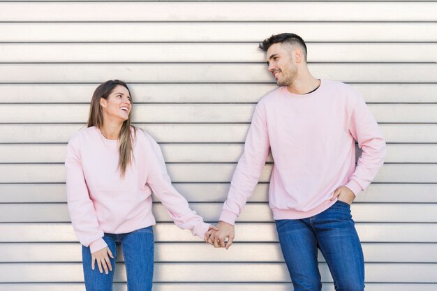 Jeune femme souriante, main dans la main avec beau mec heureux