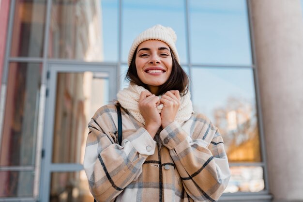 Jeune femme souriante marchant dans la rue en hiver