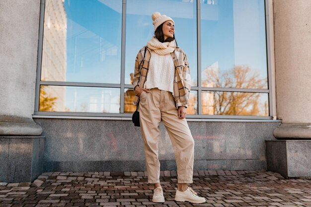 Jeune femme souriante marchant dans la rue en hiver