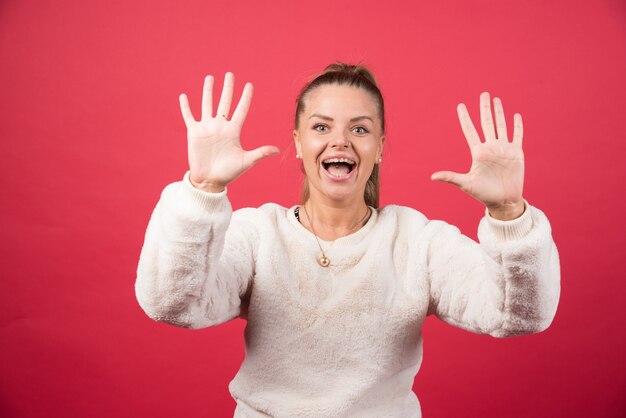 Jeune femme souriante et montrant le numéro cinq avec les doigts