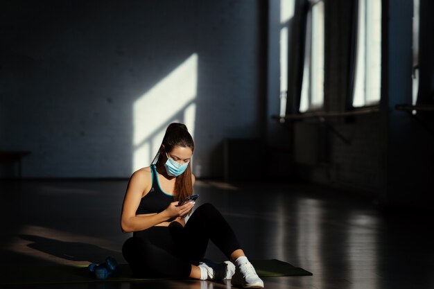 Jeune femme sportive après avoir pratiqué le yoga, pause en faisant de l'exercice, se détendre sur un tapis de yoga