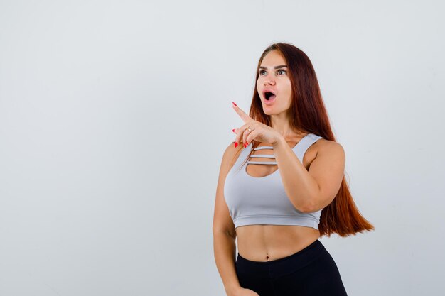 Jeune femme sportive aux cheveux longs dans un haut gris