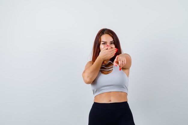 Jeune femme sportive aux cheveux longs dans un haut gris