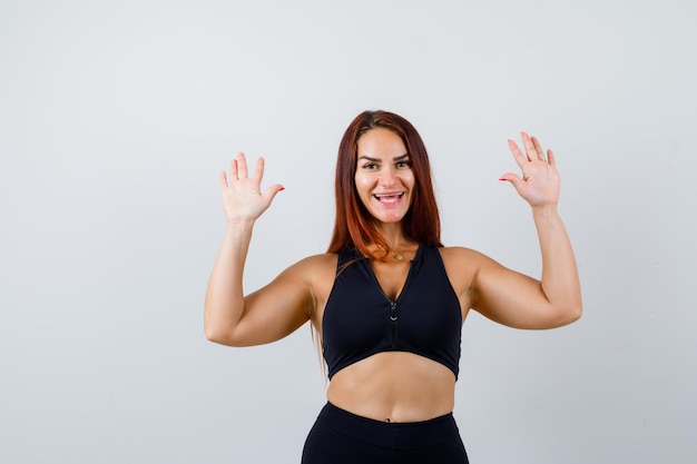 Jeune femme sportive aux cheveux longs dans un haut noir