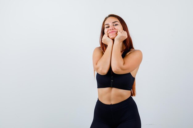 Jeune femme sportive aux cheveux longs dans un haut noir