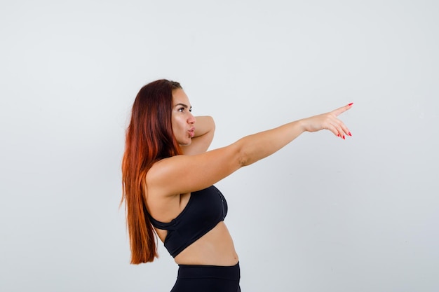 Jeune femme sportive aux cheveux longs dans un haut noir