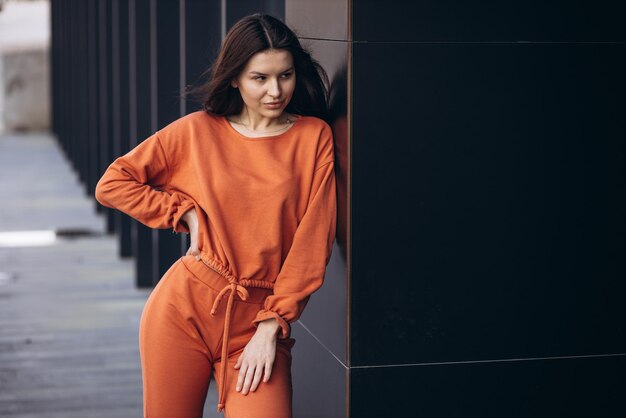 Jeune femme sportive dans un costume de sport orange