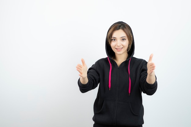 Jeune femme sportive debout et montrant la taille avec les mains. Photo de haute qualité