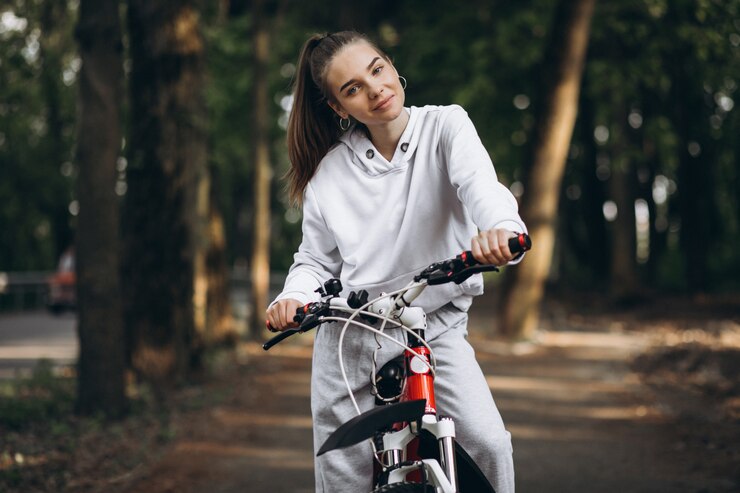 Photo gratuit jeune femme sportive, faire du vélo dans le parc
