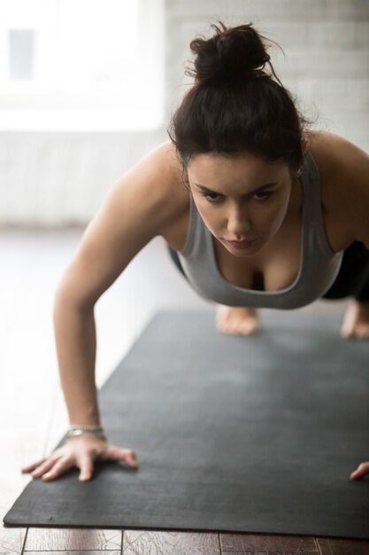 Jeune femme sportive faisant des exercices de presse, studio loft blanc