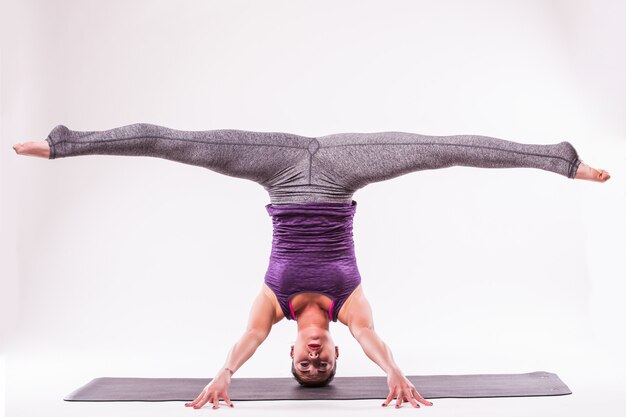 Jeune femme sportive faisant la pratique du yoga isolé sur fond blanc - concept de vie saine et équilibre naturel entre le corps et le développement mental