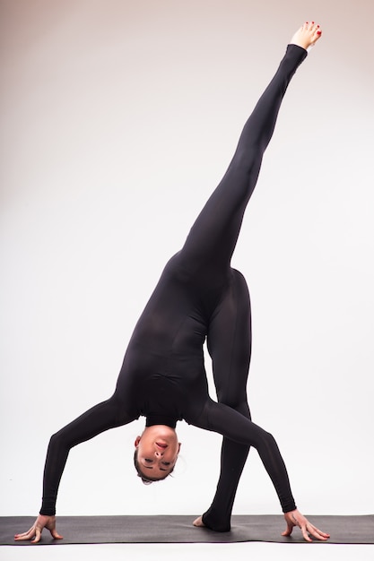 Jeune femme sportive faisant la pratique du yoga isolé sur fond blanc - concept de vie saine et équilibre naturel entre le corps et le développement mental