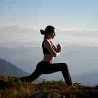 Photo gratuite jeune femme sportive pratiquant le yoga dans les montagnes