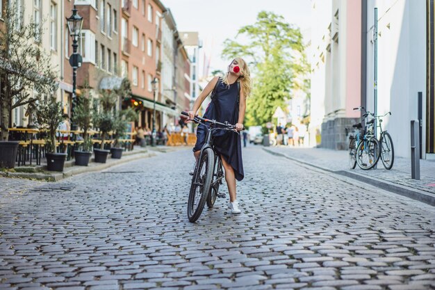 Jeune femme sportive à vélo dans une ville européenne. Sports en milieu urbain.