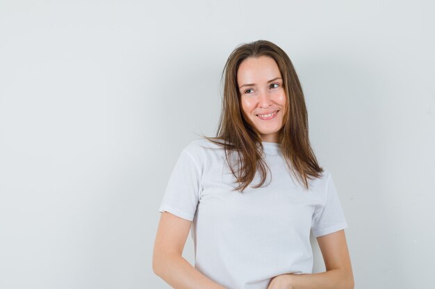 Jeune femme en t-shirt blanc en détournant les yeux et à la charmante