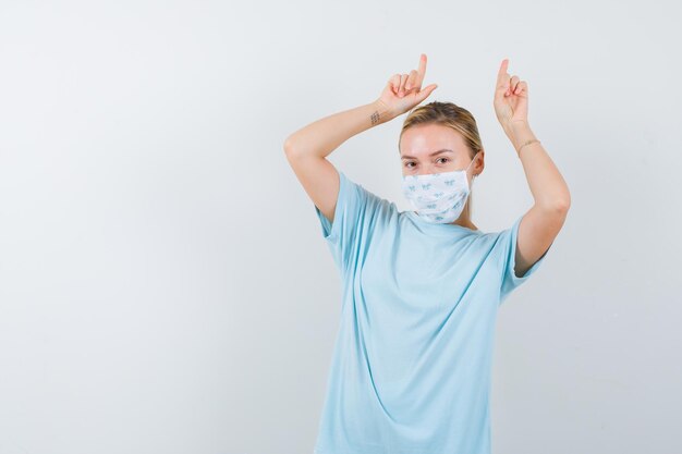 Jeune femme en t-shirt bleu avec un masque médical