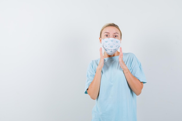 Jeune femme en t-shirt bleu avec un masque médical