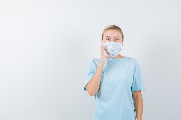 Jeune femme en t-shirt bleu avec un masque médical