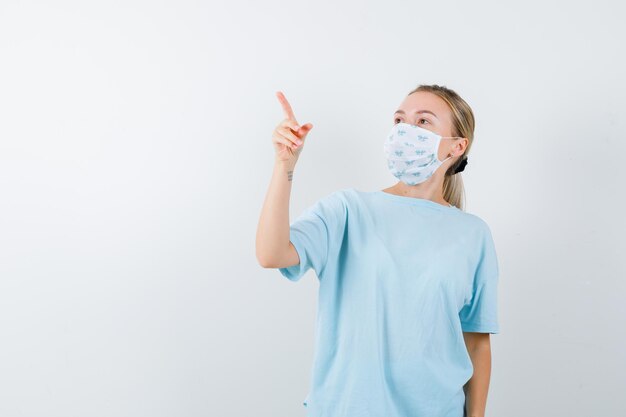 Jeune femme en t-shirt bleu avec un masque médical