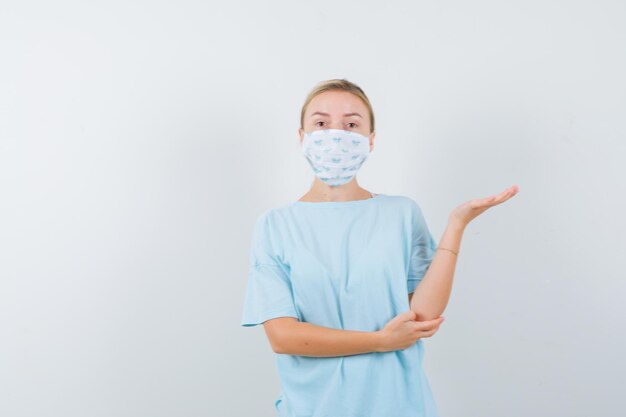 Jeune femme en t-shirt bleu avec un masque médical