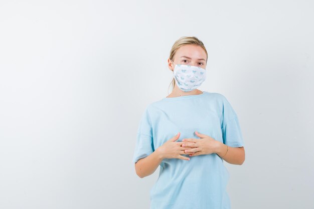 Jeune femme en t-shirt bleu avec un masque médical