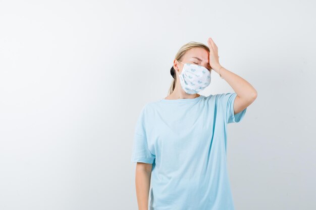 Jeune femme en t-shirt bleu avec un masque médical