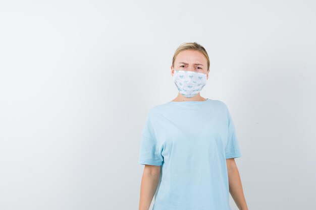 Jeune femme en t-shirt bleu avec un masque médical