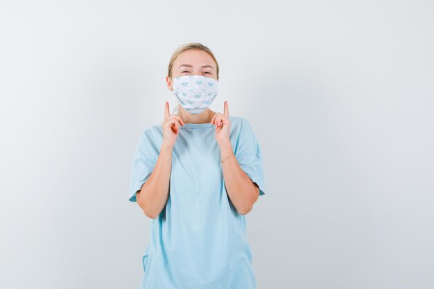 Jeune femme en t-shirt bleu avec un masque médical