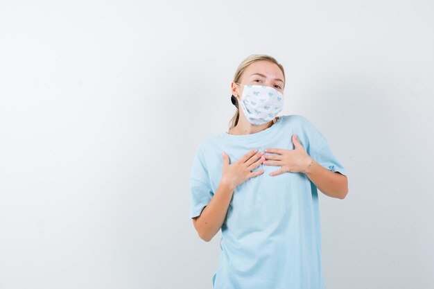 Jeune femme en t-shirt bleu avec un masque médical